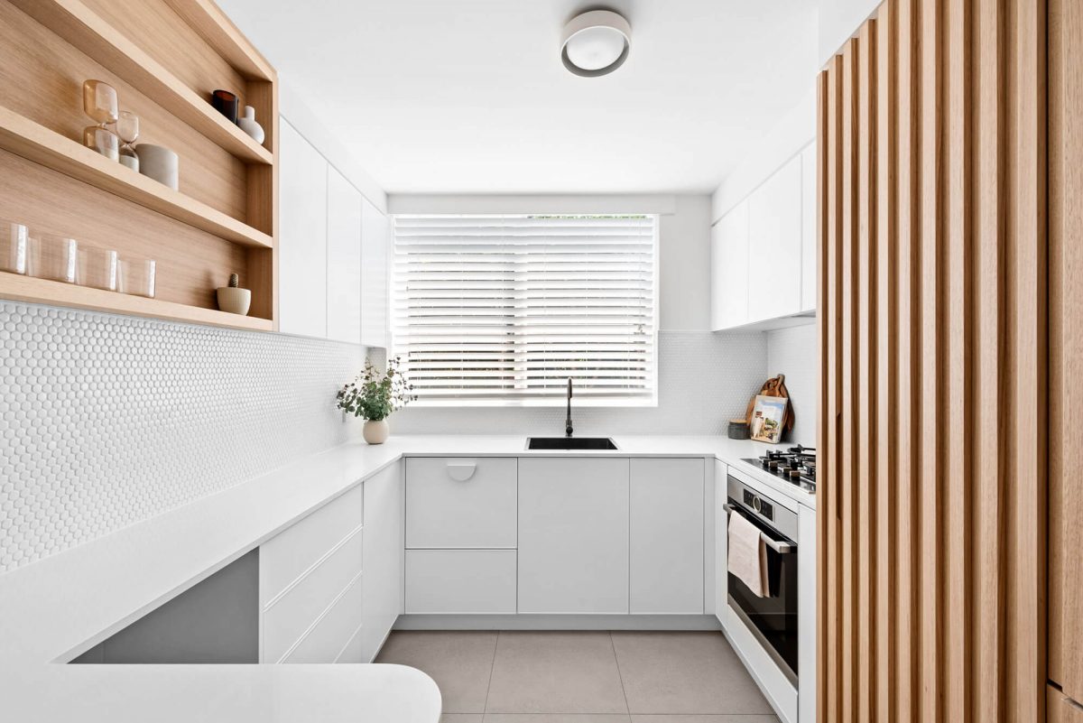 A custom designed kitchen with a timber and white design. Designed and built by MJ Harris Group.