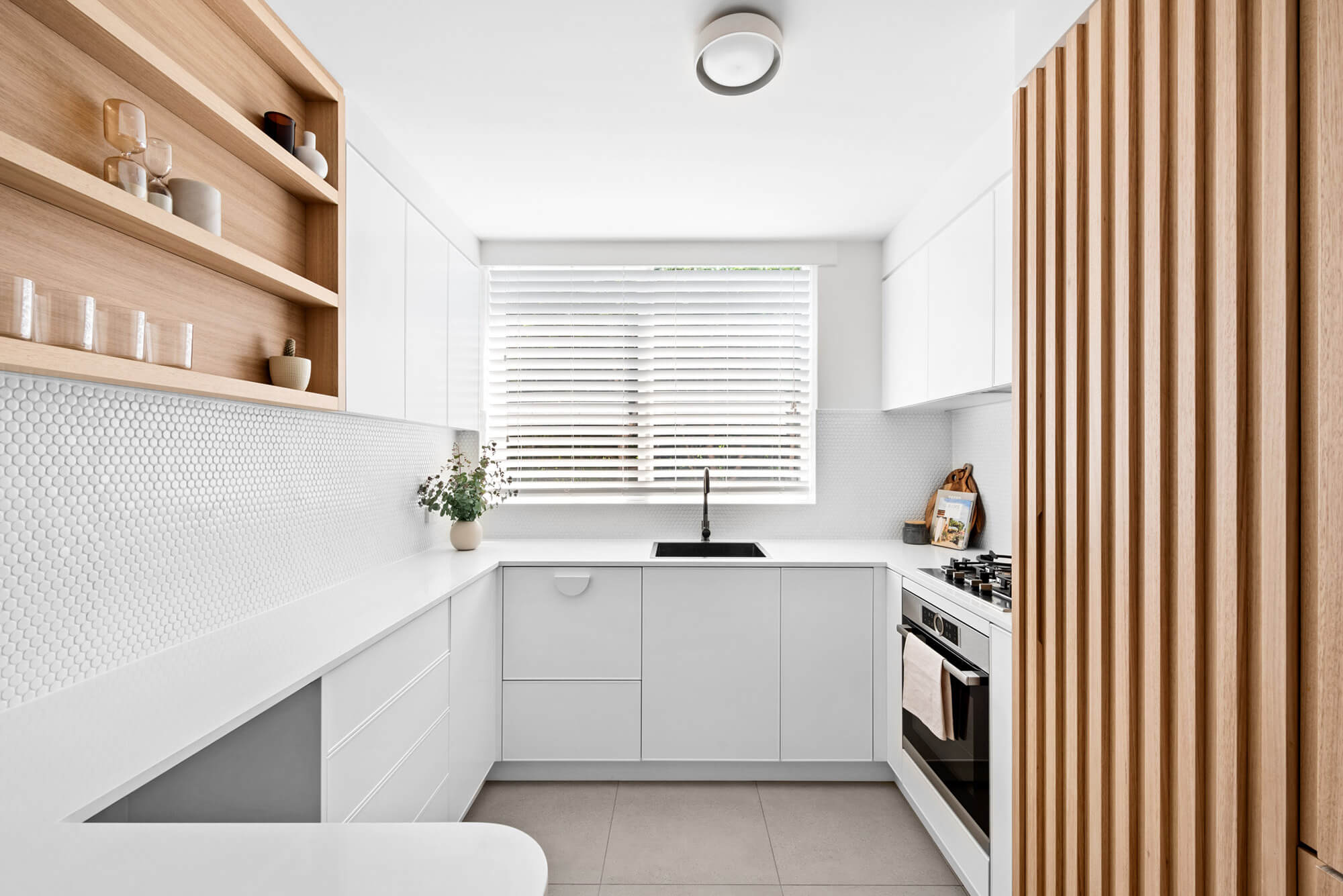 A custom designed kitchen with a timber and white design. Designed and built by MJ Harris Group.