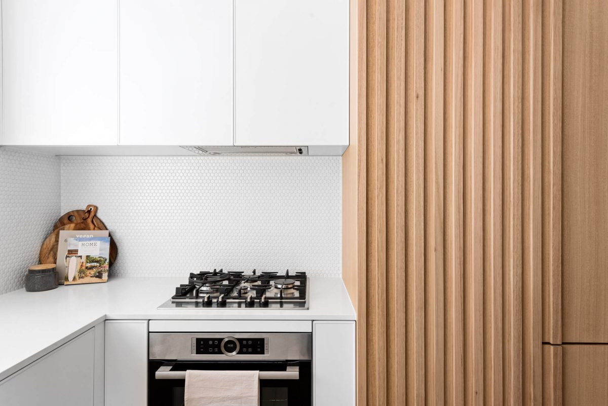 A custom designed kitchen with a timber and white design. Designed and built by MJ Harris Group.