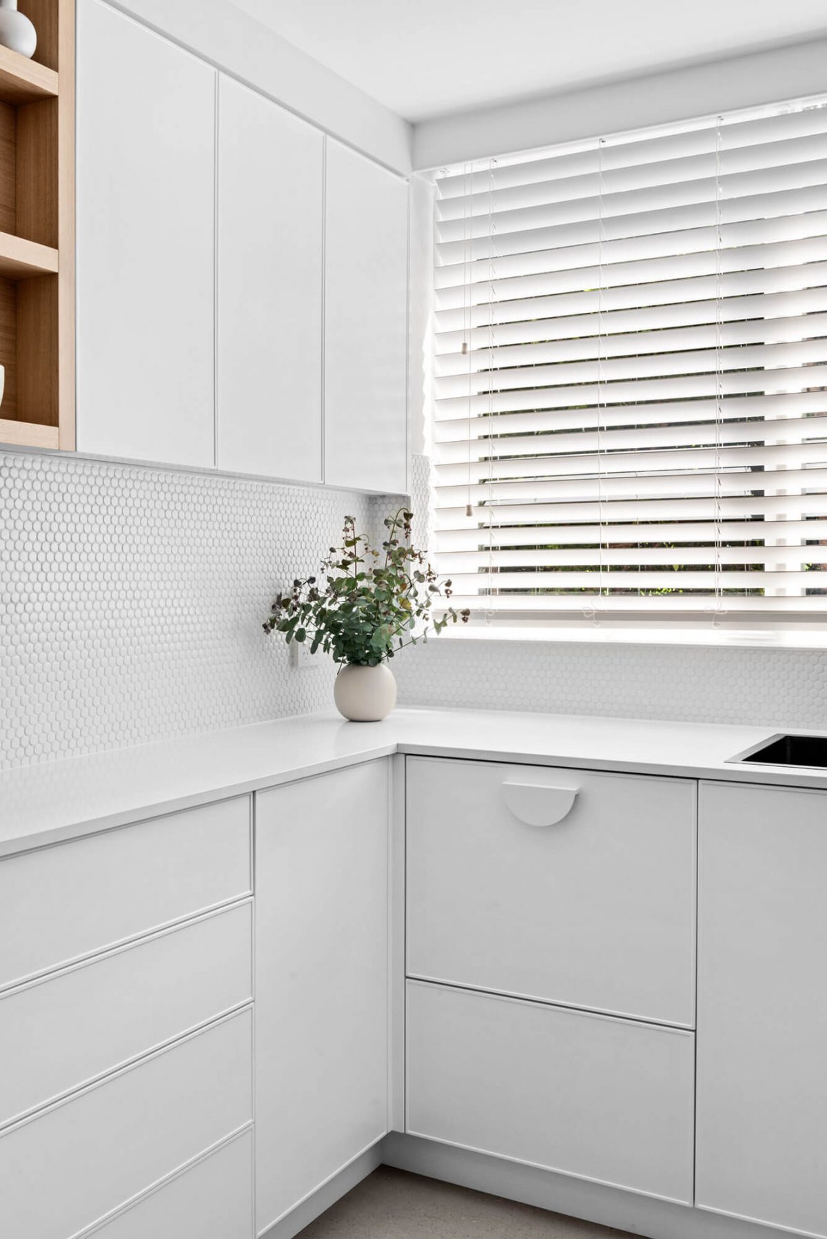 A custom designed kitchen with a timber and white design. Designed and built by MJ Harris Group.