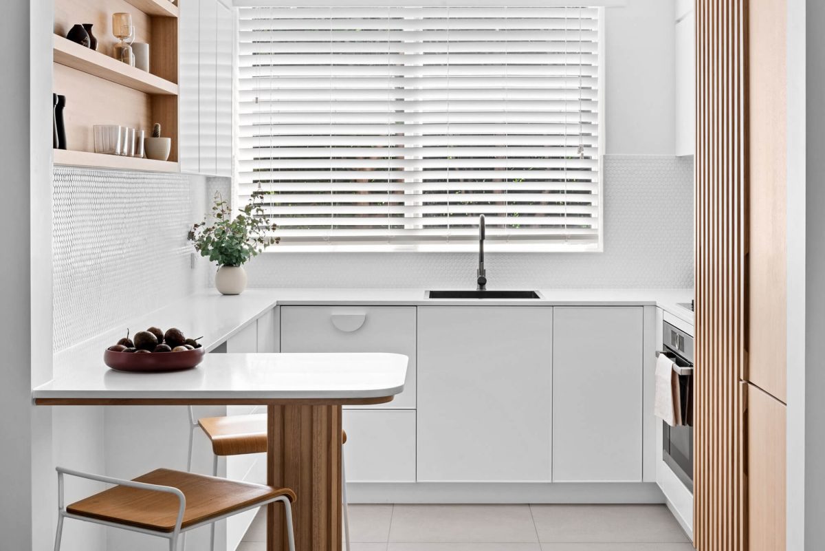 A custom designed kitchen with a timber and white design. Designed and built by MJ Harris Group.