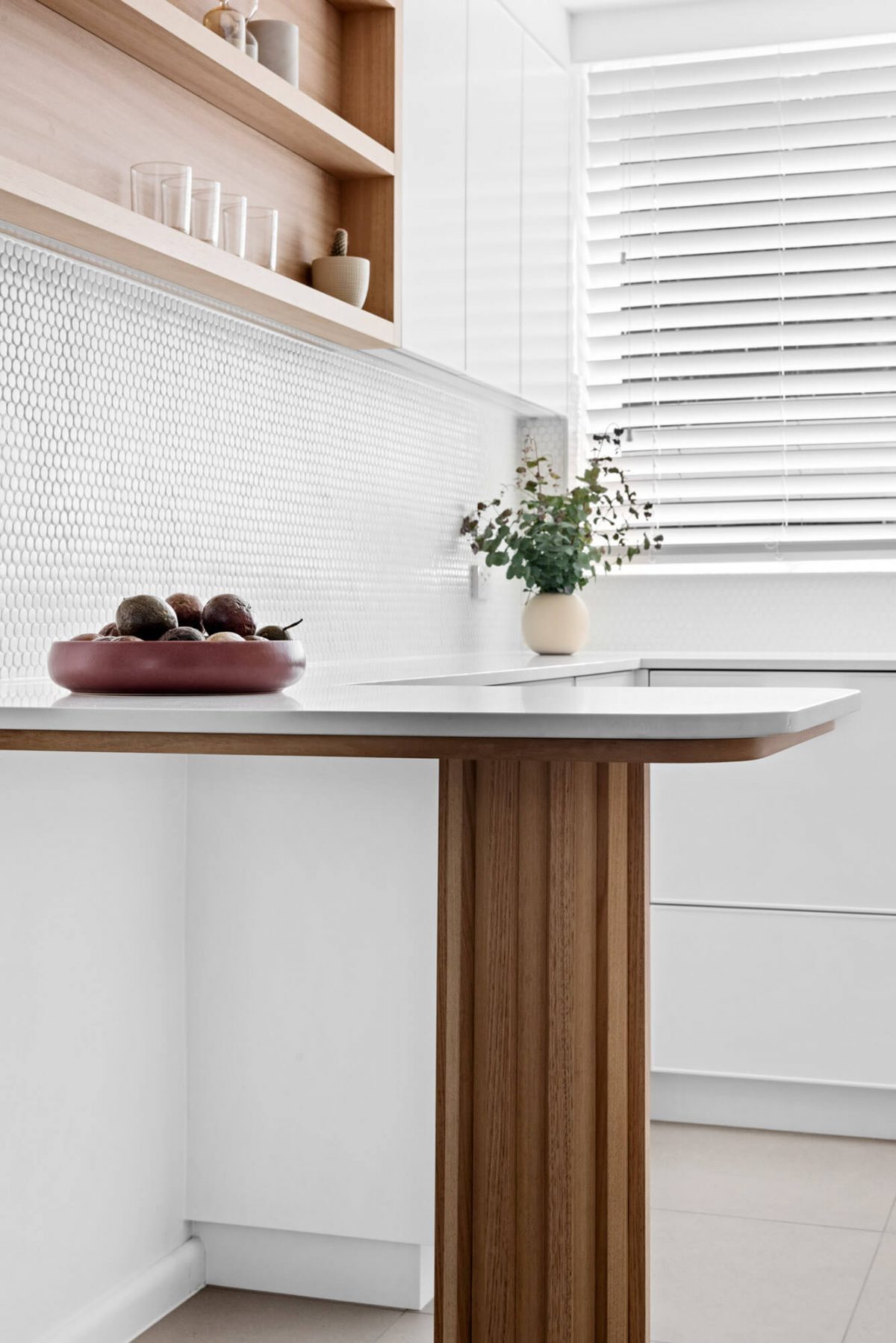 A custom designed kitchen with a timber and white design. Designed and built by MJ Harris Group.