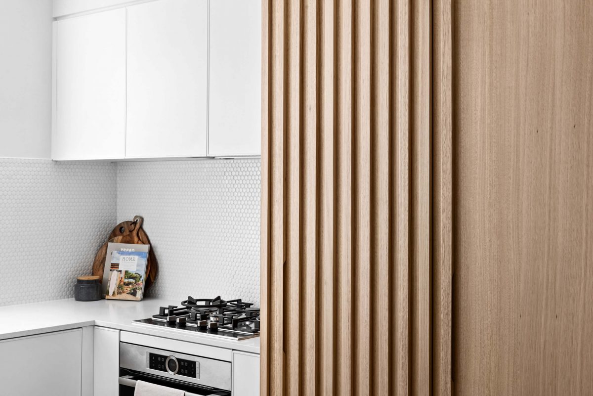 A custom designed kitchen with a timber and white design. Designed and built by MJ Harris Group.