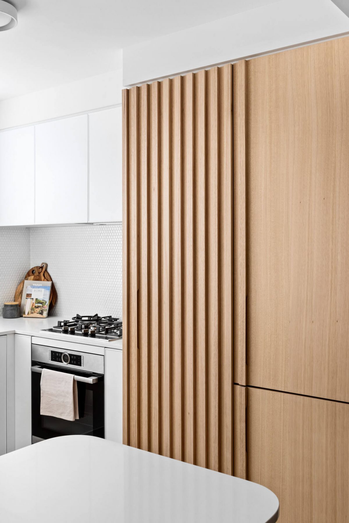 A custom designed kitchen with a timber and white design. Designed and built by MJ Harris Group.