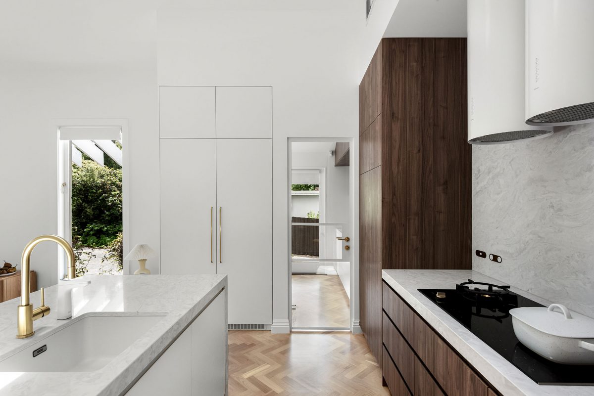 A custom designed kitchen featuring a cylindrical Rangehood. Designed and built by MJ Harris Group.