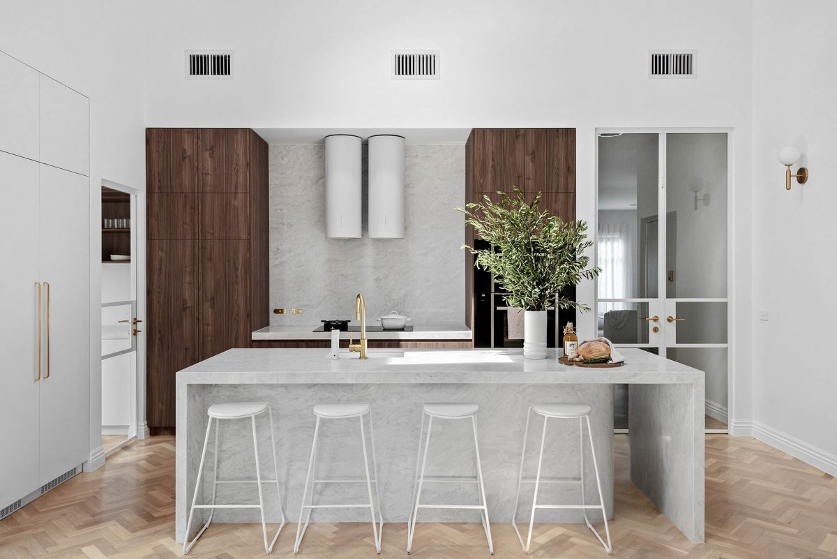 A custom designed kitchen featuring a cylindrical Rangehood. Designed and built by MJ Harris Group.
