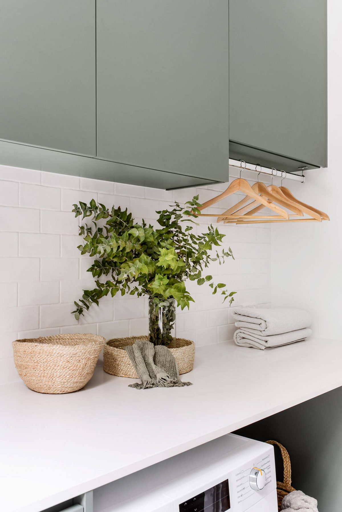 A custom designed laundry featuring green joinery. Designed and built by MJ Harris Group.