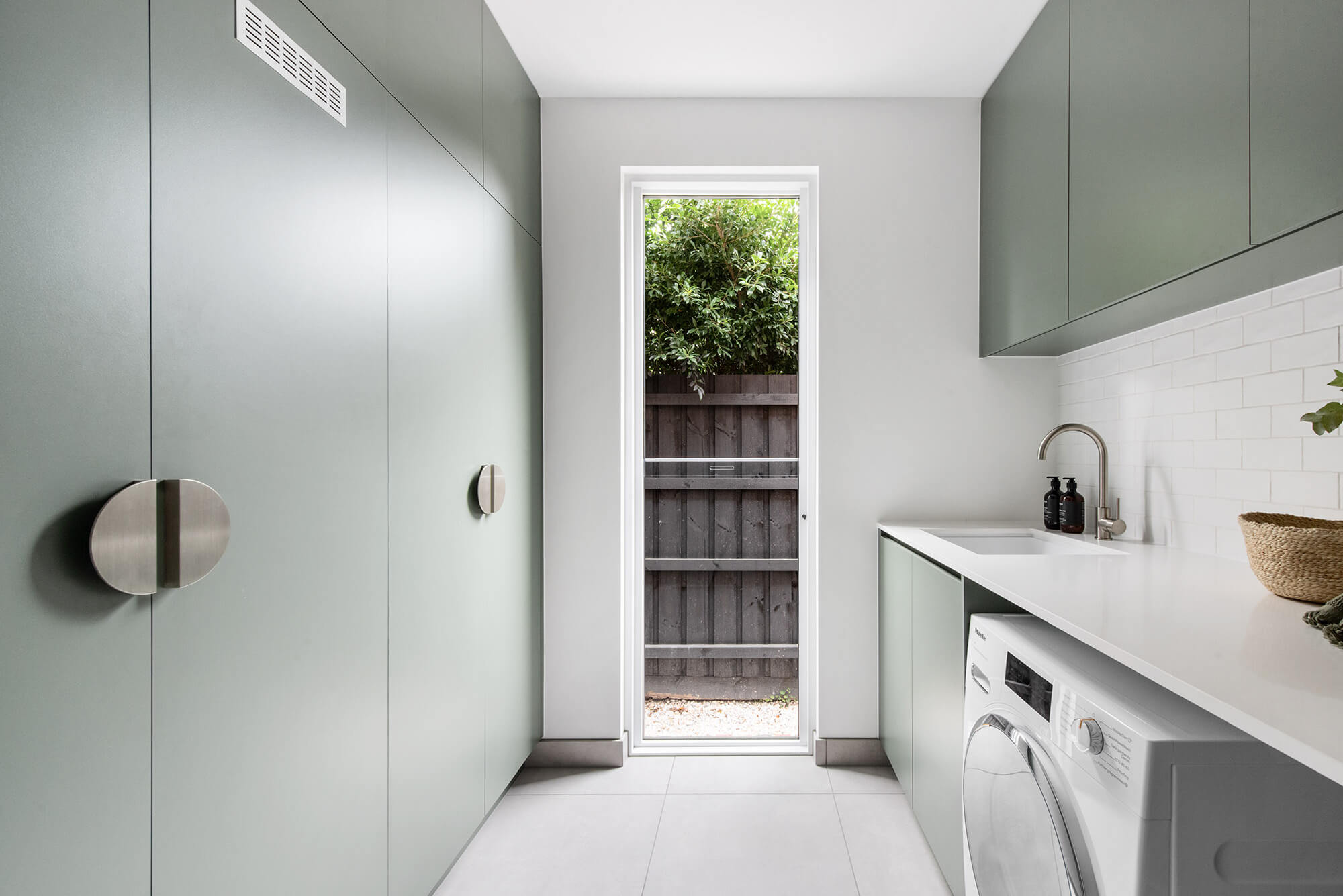 A custom designed laundry featuring green joinery. Designed and built by MJ Harris Group.
