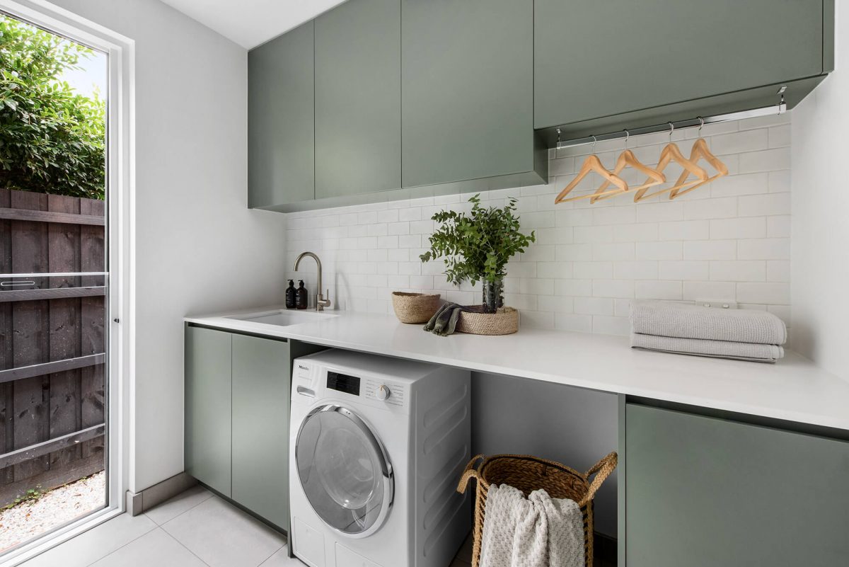 A custom designed laundry featuring green joinery. Designed and built by MJ Harris Group.