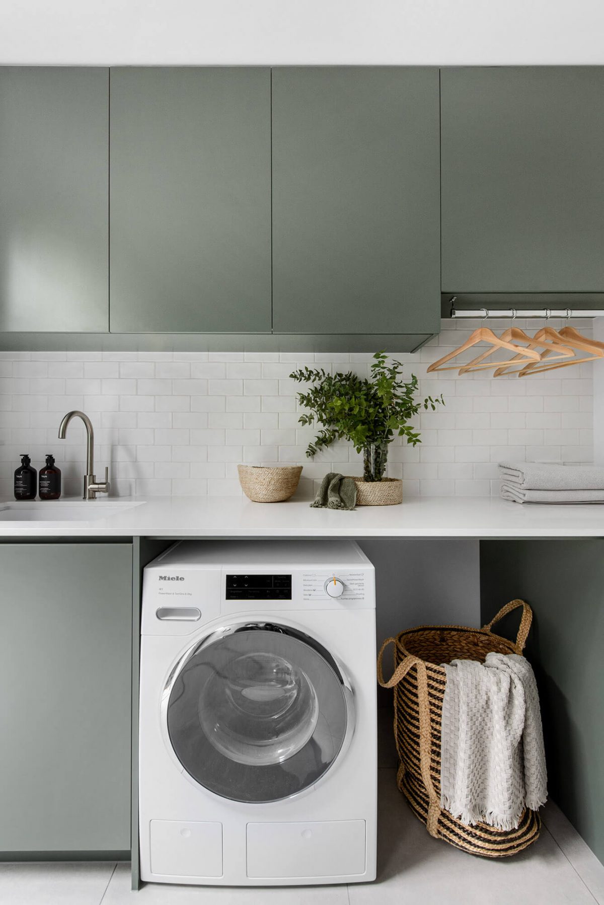 A custom designed laundry featuring green joinery. Designed and built by MJ Harris Group.