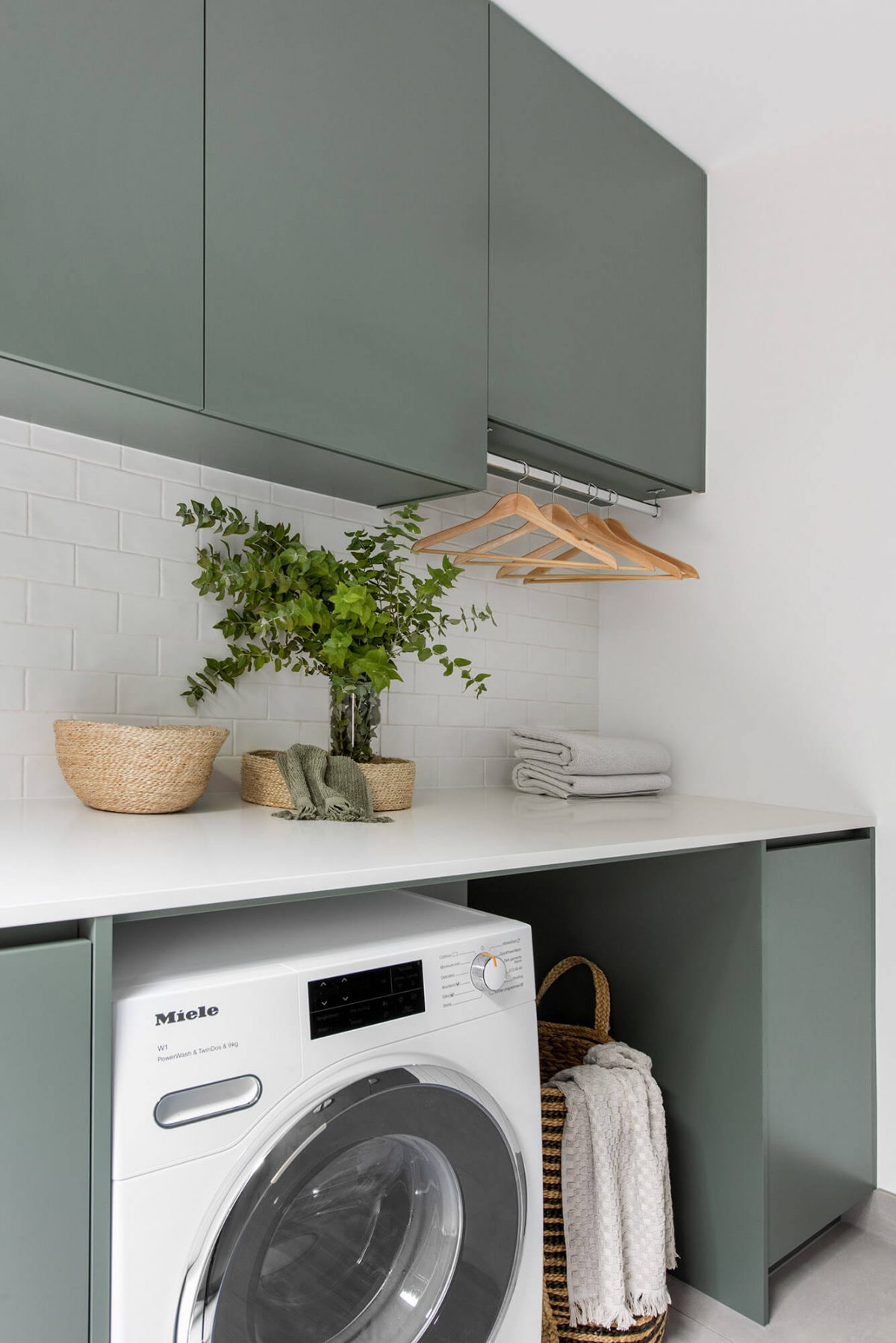 A custom designed laundry featuring green joinery. Designed and built by MJ Harris Group.