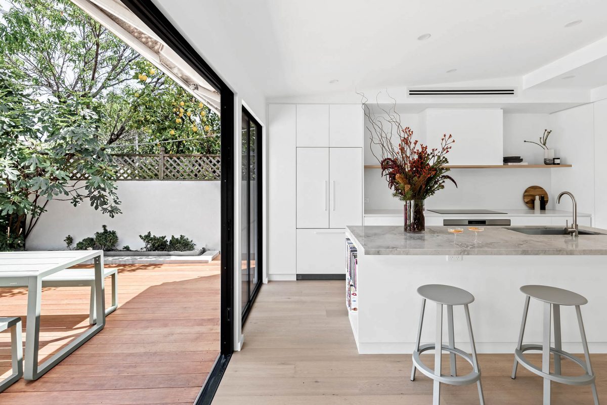 A custom designed kitchen featuring a stone benchtop and white custom joinery. Designed and built by MJ Harris Group. #MJHxEdinburghSt