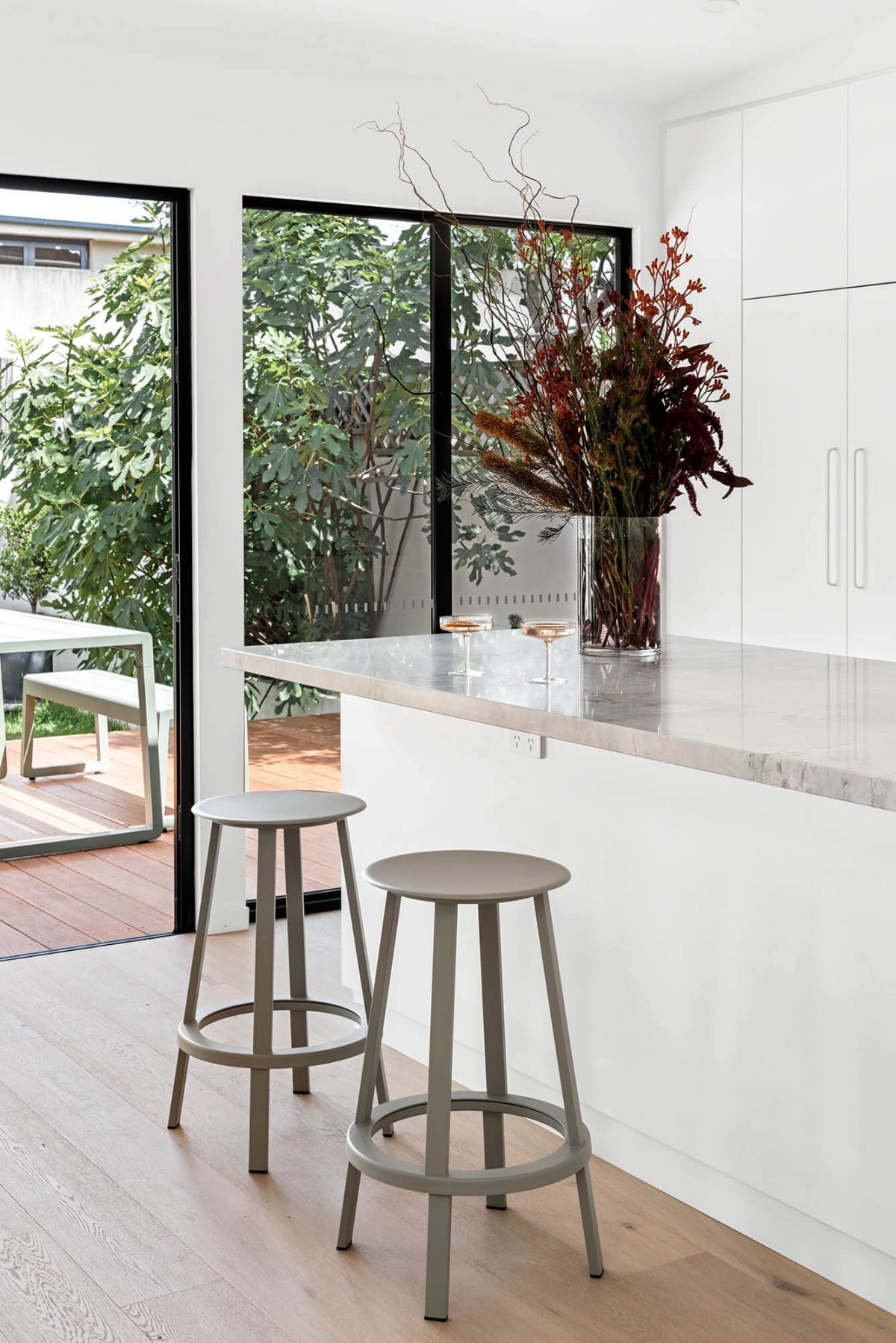 A custom designed kitchen featuring a stone benchtop and white custom joinery. Designed and built by MJ Harris Group. #MJHxEdinburghSt