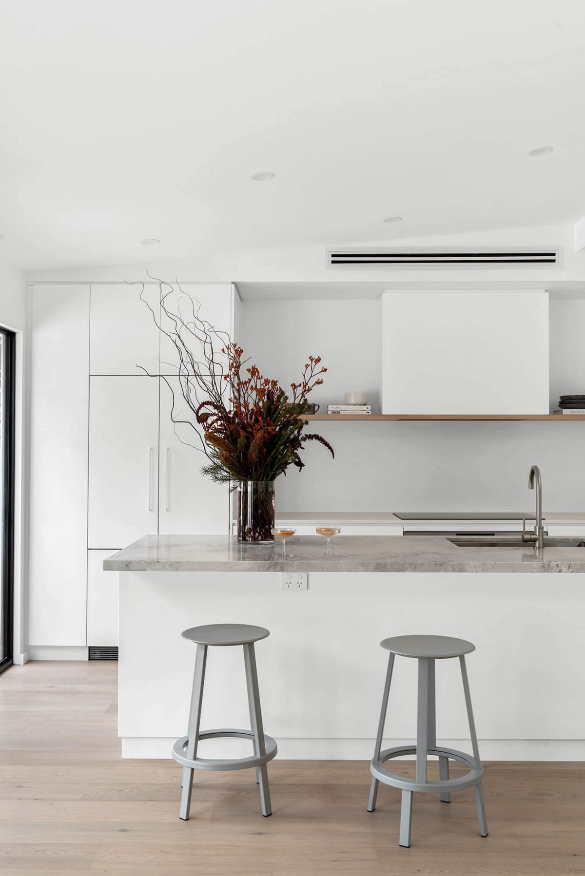 A custom designed kitchen featuring a stone benchtop and white custom joinery. Designed and built by MJ Harris Group. #MJHxEdinburghSt