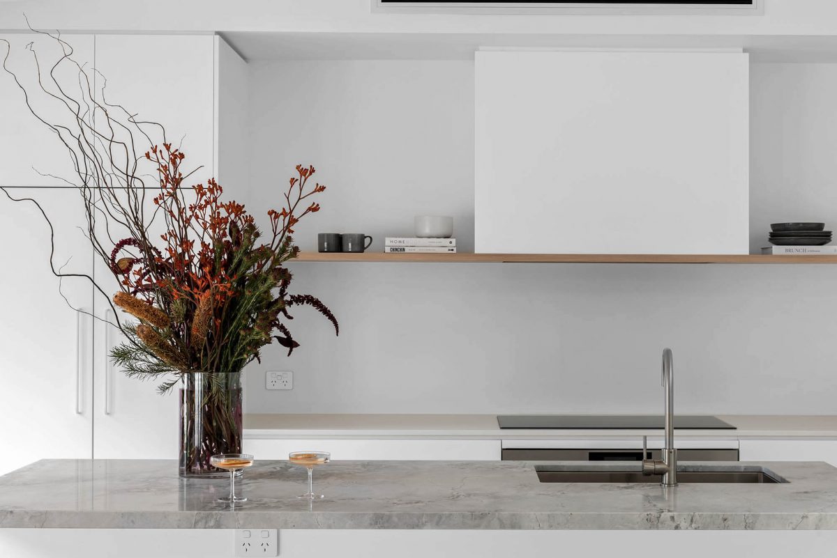 A custom designed kitchen featuring a stone benchtop and white custom joinery. Designed and built by MJ Harris Group. #MJHxEdinburghSt
