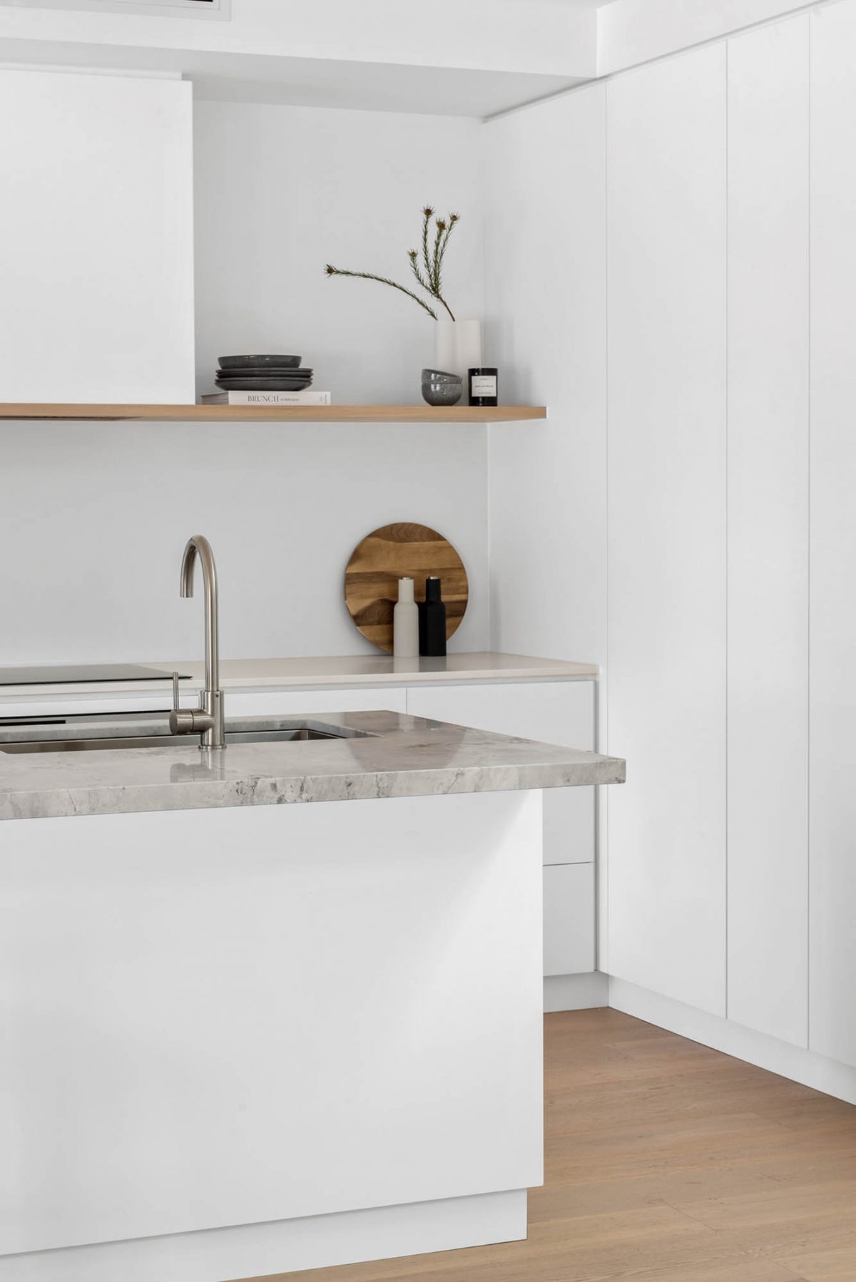 A custom designed kitchen featuring a stone benchtop and white custom joinery. Designed and built by MJ Harris Group. #MJHxEdinburghSt