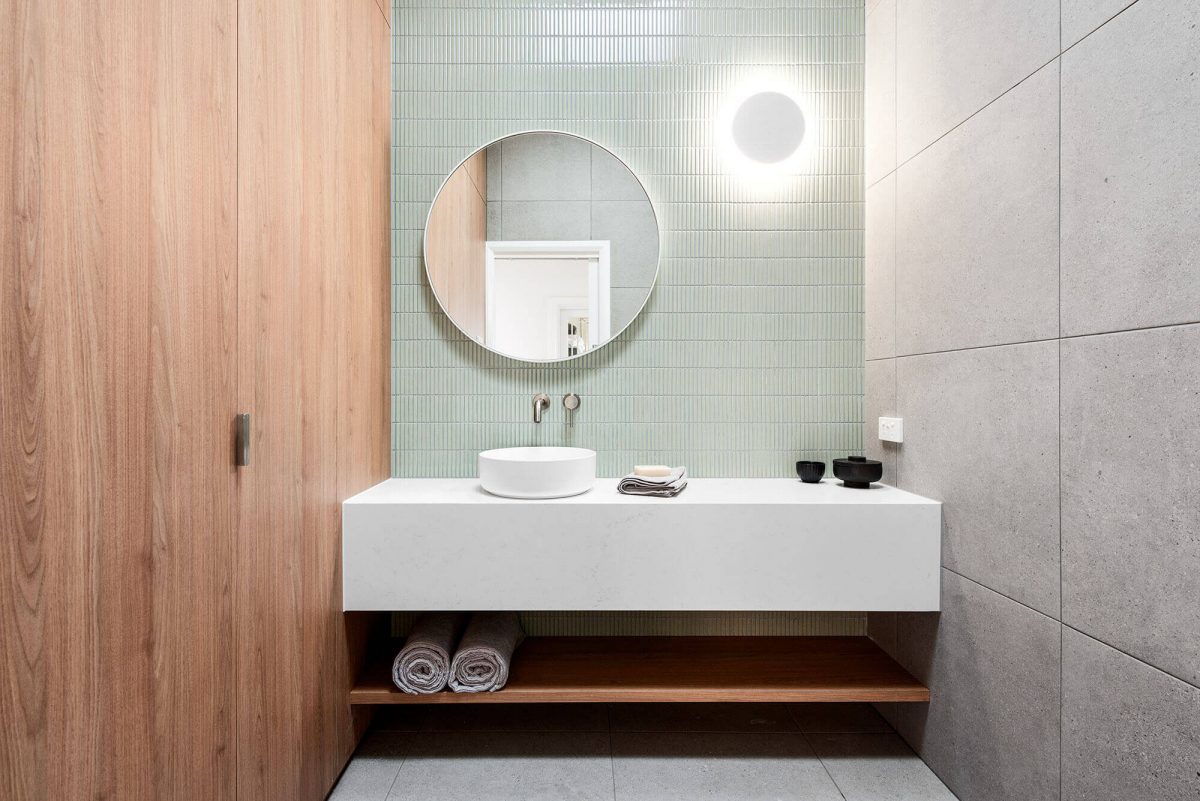 A custom designed laundry featuring green tiles. Designed and built by MJ Harris Group.