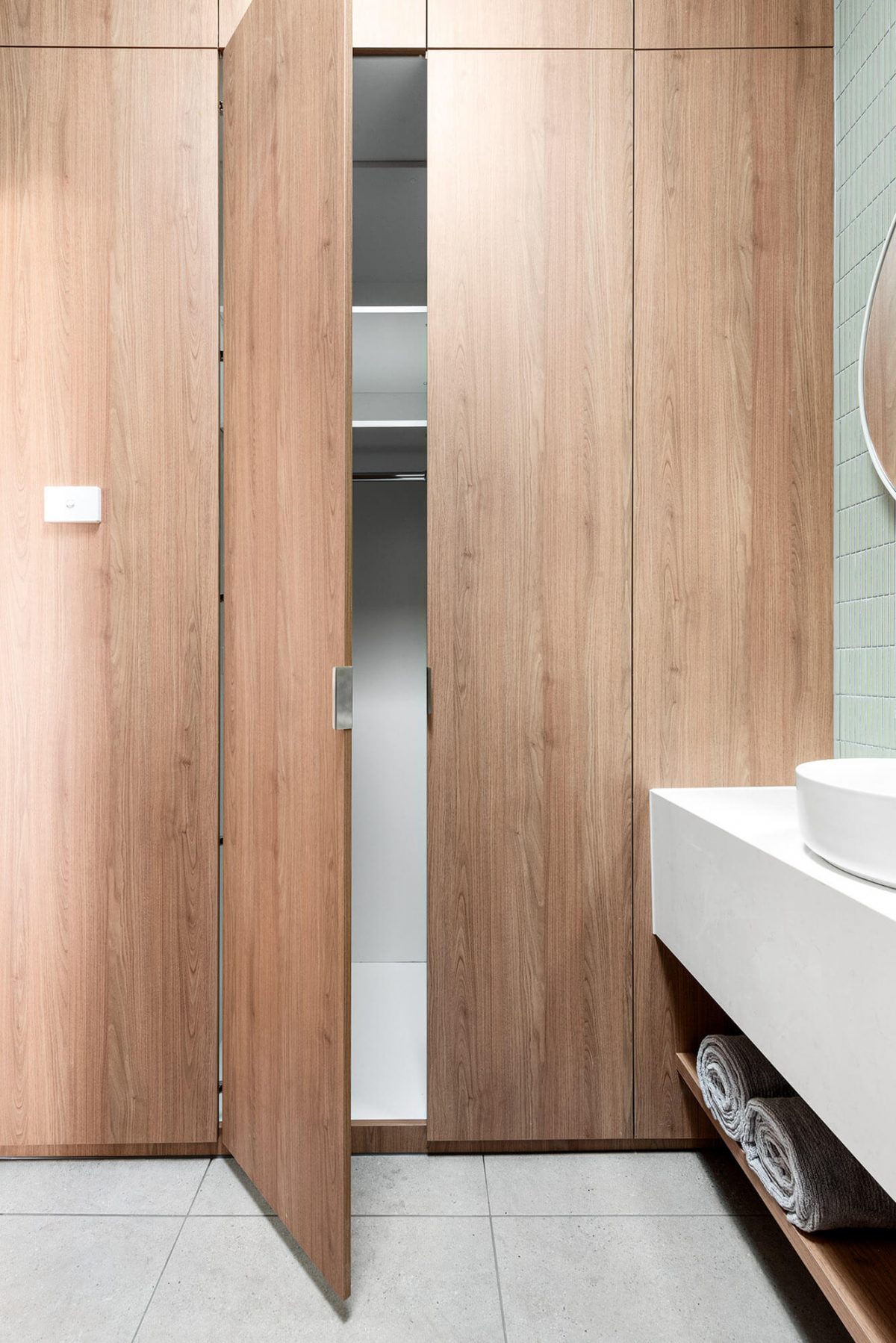 A custom designed laundry featuring green tiles. Designed and built by MJ Harris Group.