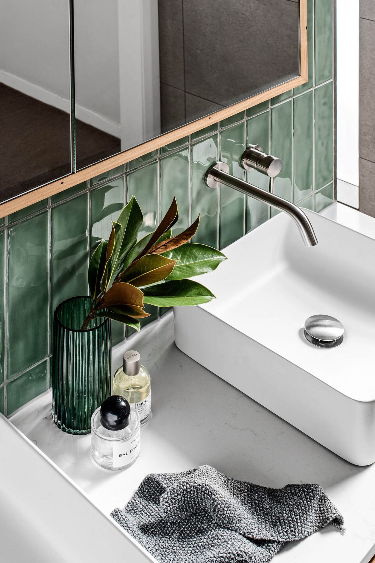 A custom designed laundry featuring green tiles. Designed and built by MJ Harris Group.