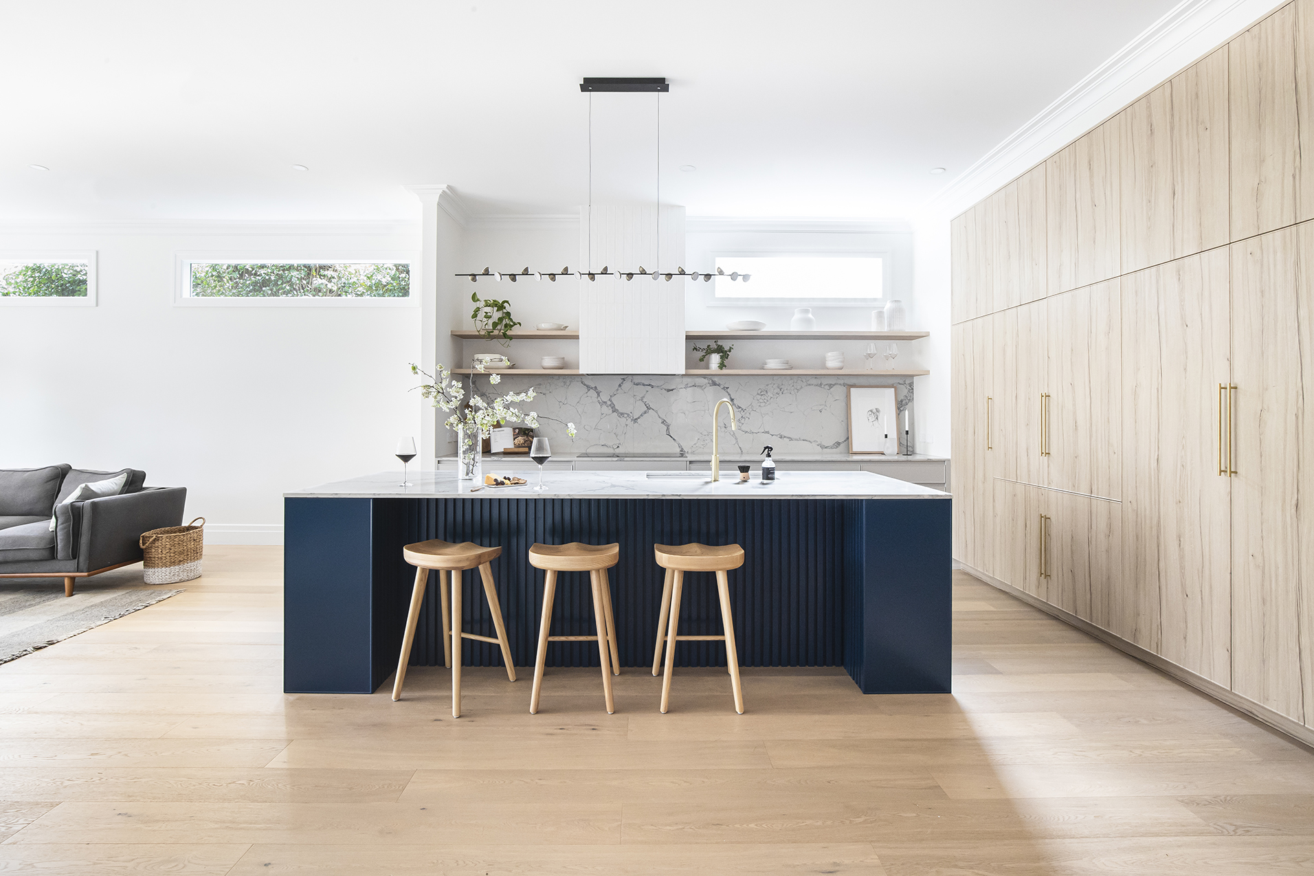 A custom designed kitchen featuring custom blue island. Designed and built by MJ Harris Group.