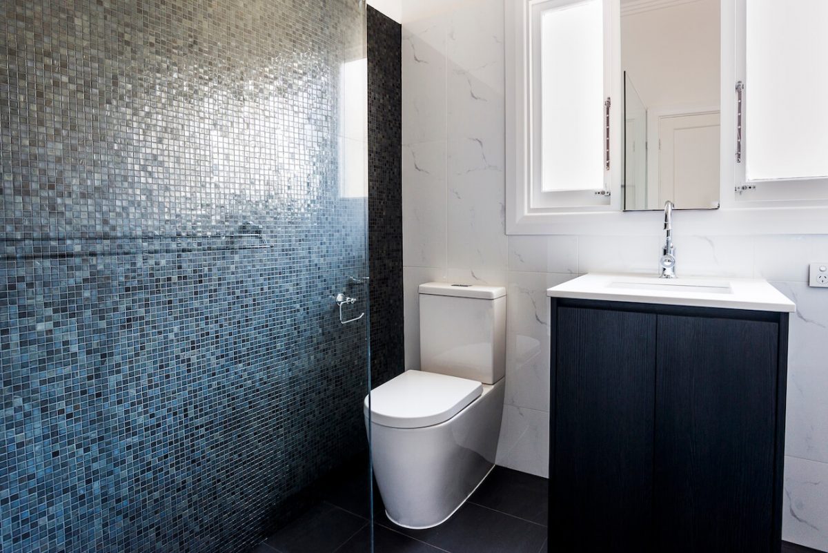 A custom designed bathroom featuring a blue tiled wall. Designed and built by MJ Harris Group. #MJHxSheirsSt