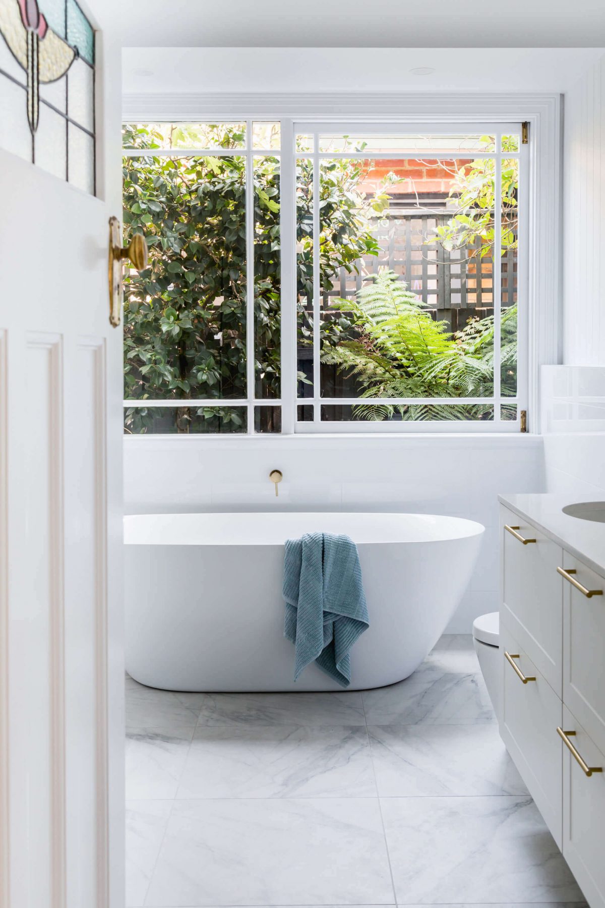 A custom designed bathroom featuring gold fixtures. Designed and built by MJ Harris Group. #MJHxSycamoreSt
