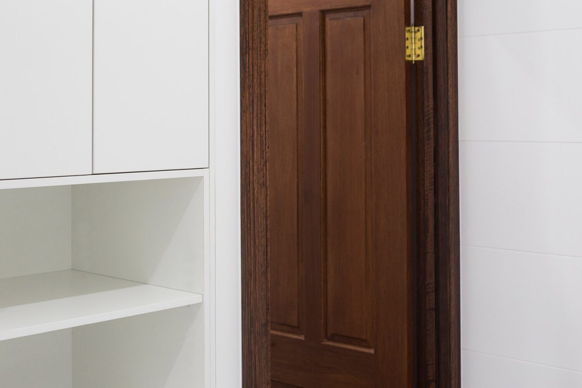 A custom designed bathroom featuring a timber folding doors. Designed and built by MJ Harris Group.