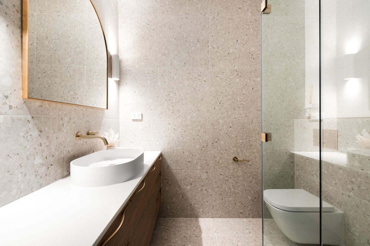 A custom designed bathroom featuring gold accents. Designed and built by MJ Harris Group.