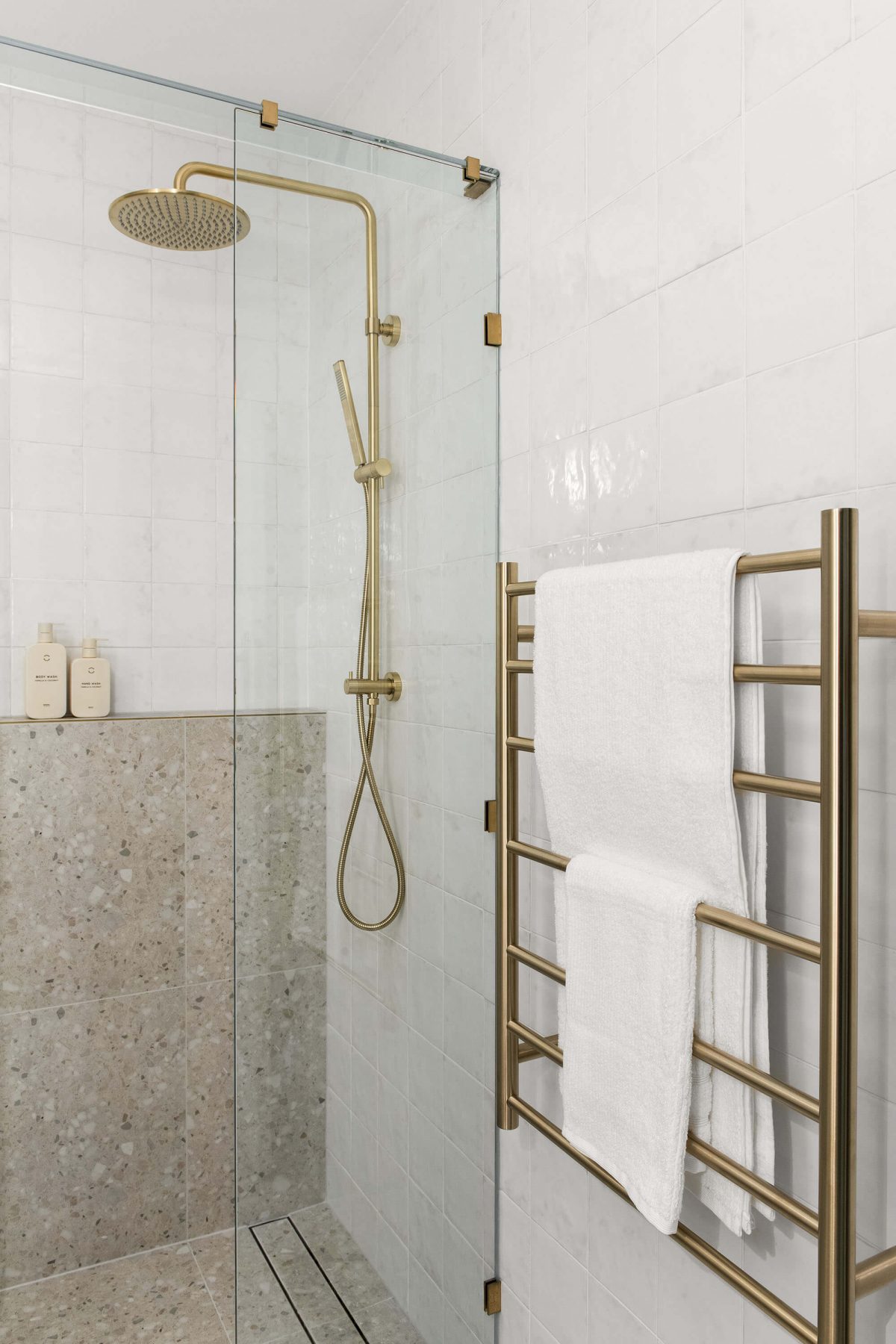 A custom designed bathroom featuring gold accents. Designed and built by MJ Harris Group.
