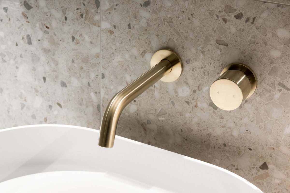 A custom designed bathroom featuring gold accents. Designed and built by MJ Harris Group.