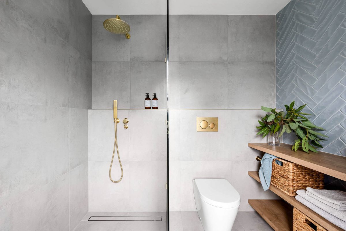 A custom designed bathroom featuring blue tiles in a herringbone pattern. Designed and built by MJ Harris Group.