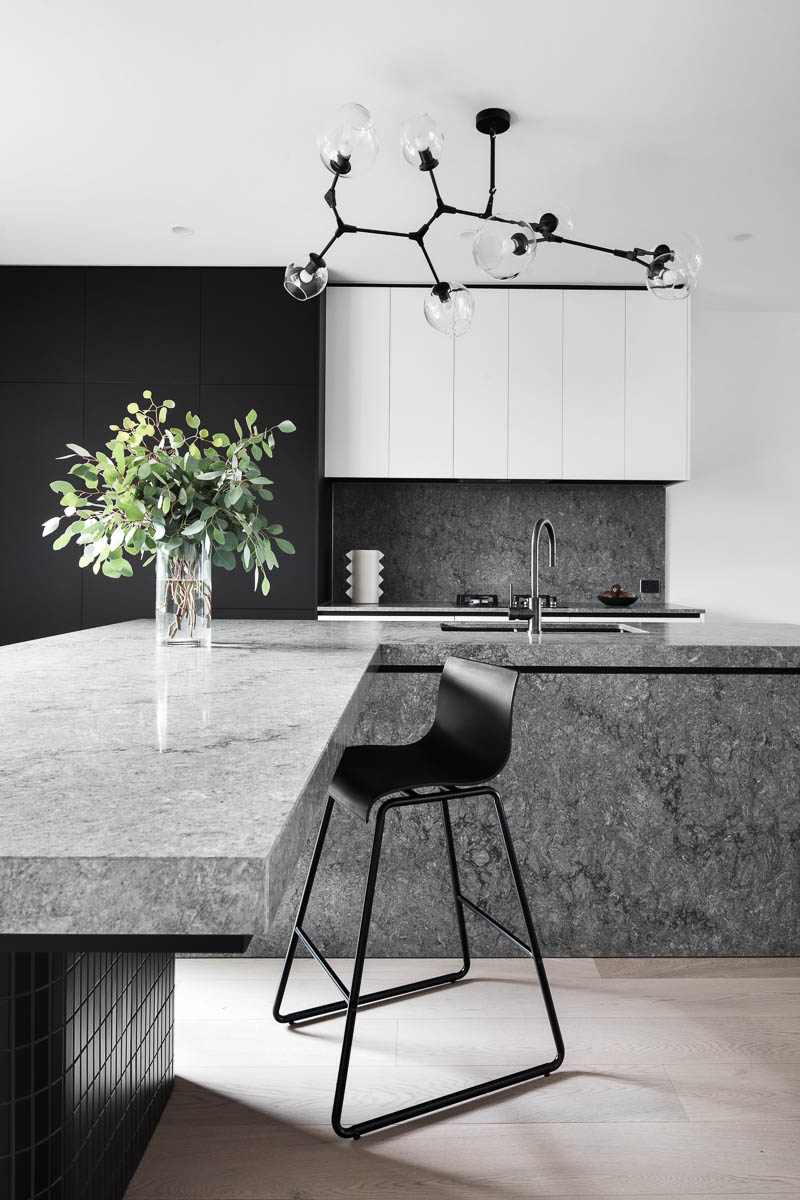 A custom designed kitchen featuring a grey caesar stone benchtop. Designed and built by MJ Harris Group.