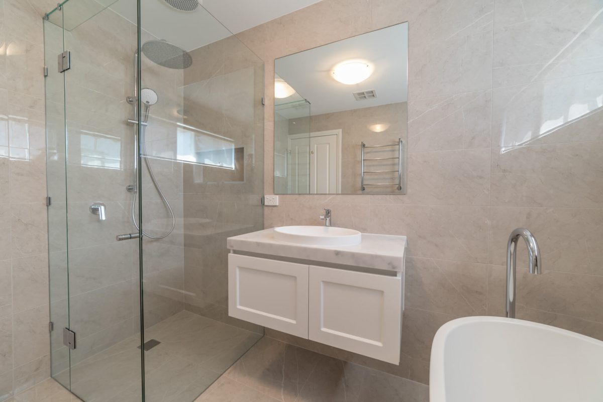 A custom designed bathroom featuring chrome fixtures. Designed and built by MJ Harris Group.