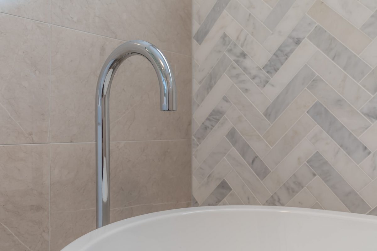 A custom designed bathroom featuring chrome fixtures. Designed and built by MJ Harris Group.