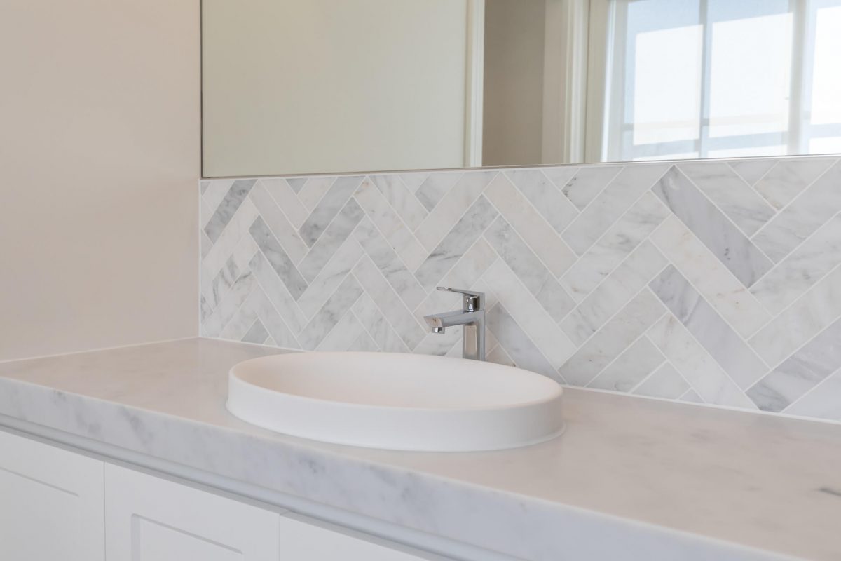 A custom designed bathroom featuring chrome fixtures. Designed and built by MJ Harris Group.