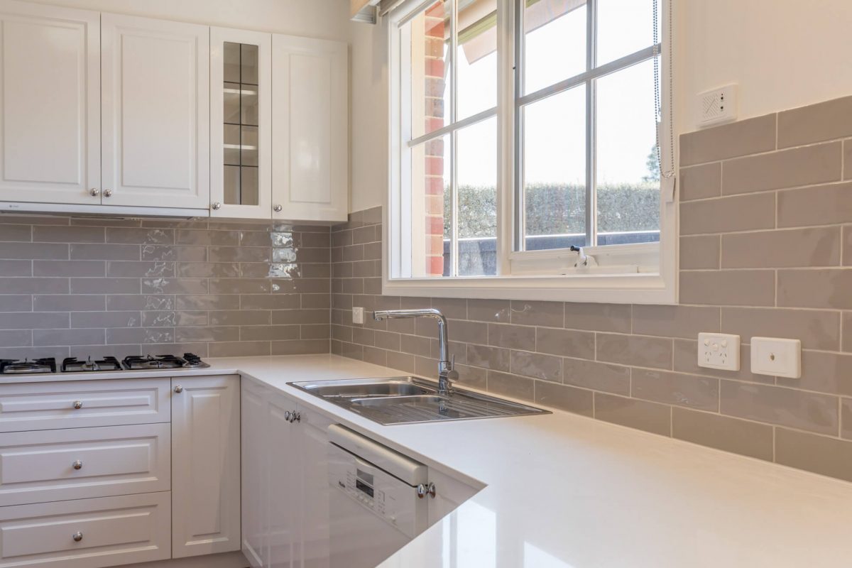 A custom designed kitchen featuring chrome tapware. Designed and built by MJ Harris Group.
