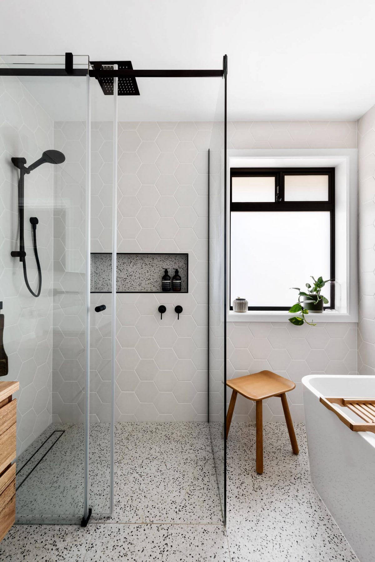 A custom designed bathroom featuring black accents. Designed and built by MJ Harris Group.