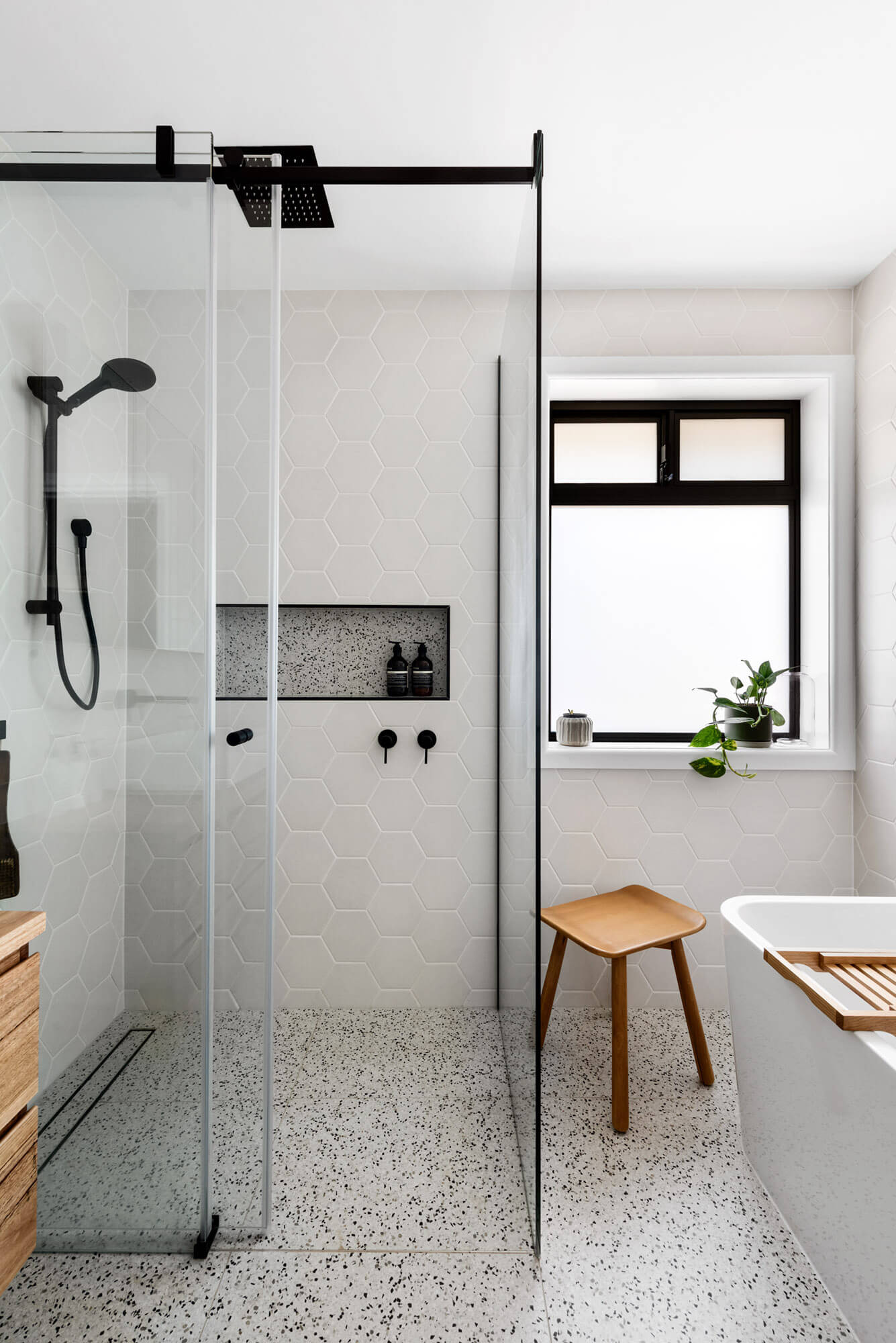 A custom designed bathroom featuring black accents. Designed and built by MJ Harris Group.