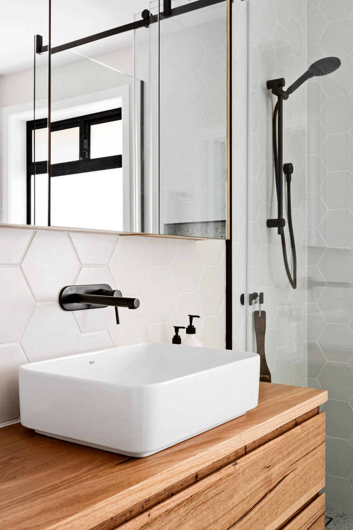 A custom designed bathroom featuring black accents. Designed and built by MJ Harris Group.
