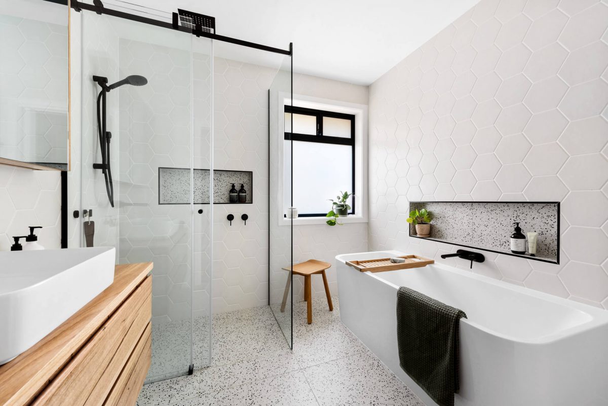 A custom designed bathroom featuring black accents. Designed and built by MJ Harris Group.