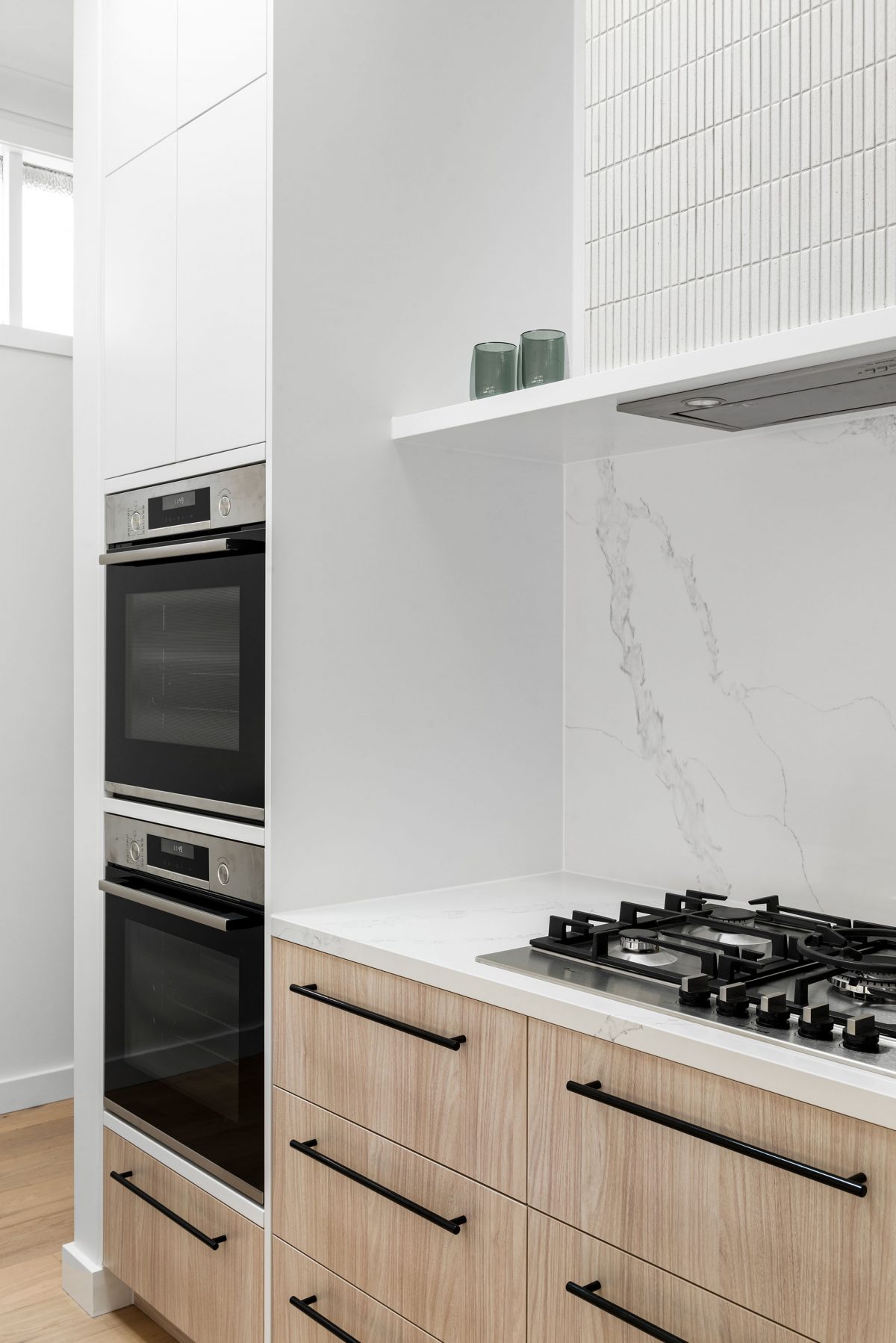 A custom designed kitchen featuring white Kit Kat files and brushed gunmetal tapware. Designed and built by MJ Harris Group. #MJHxBallantyneSt