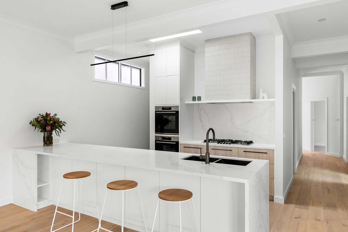 A custom designed kitchen featuring white Kit Kat files and brushed gunmetal tapware. Designed and built by MJ Harris Group. #MJHxBallantyneSt
