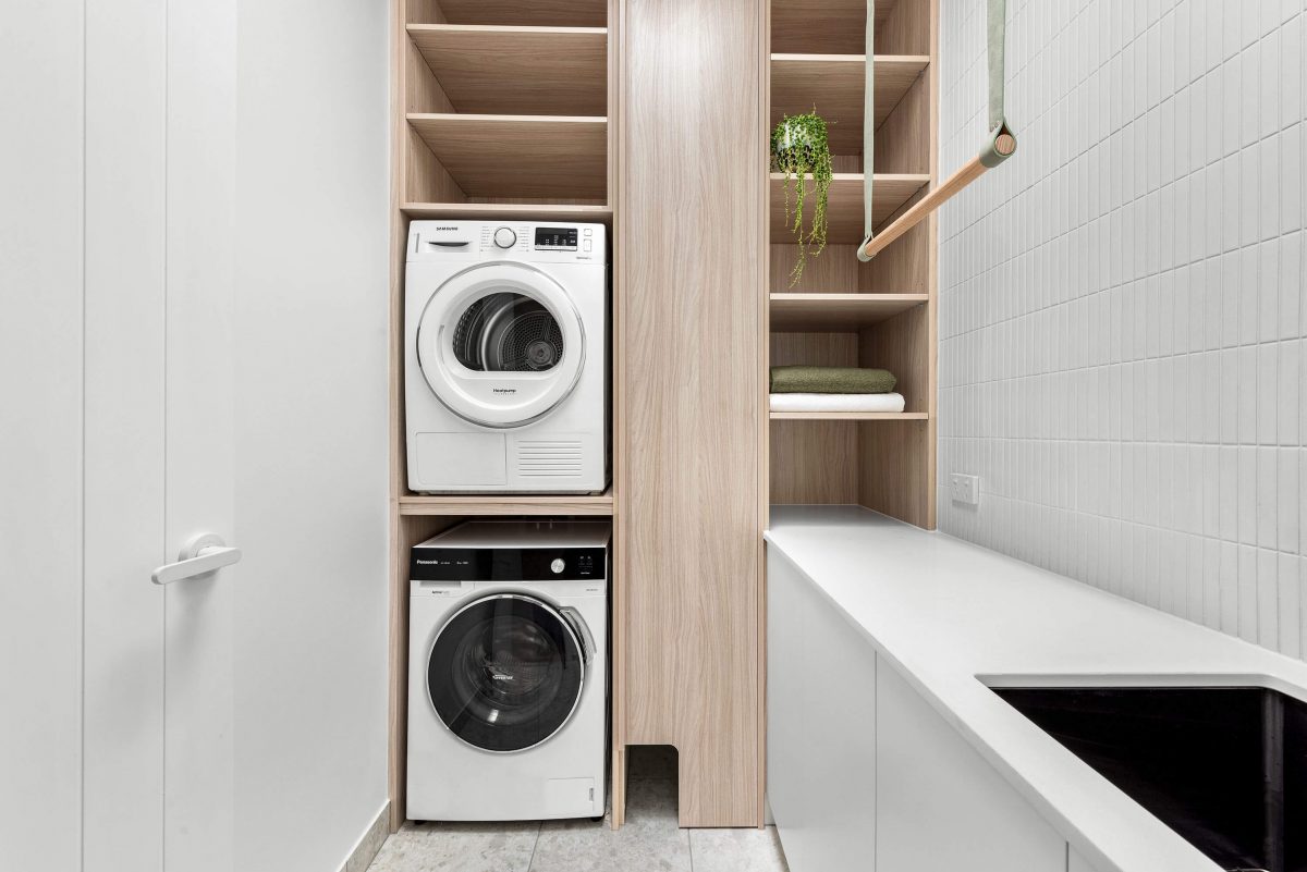 A custom designed laundry featuring a green and timber hanging rail. Designed and built by MJ Harris Group. #MJHxBallantyneSt