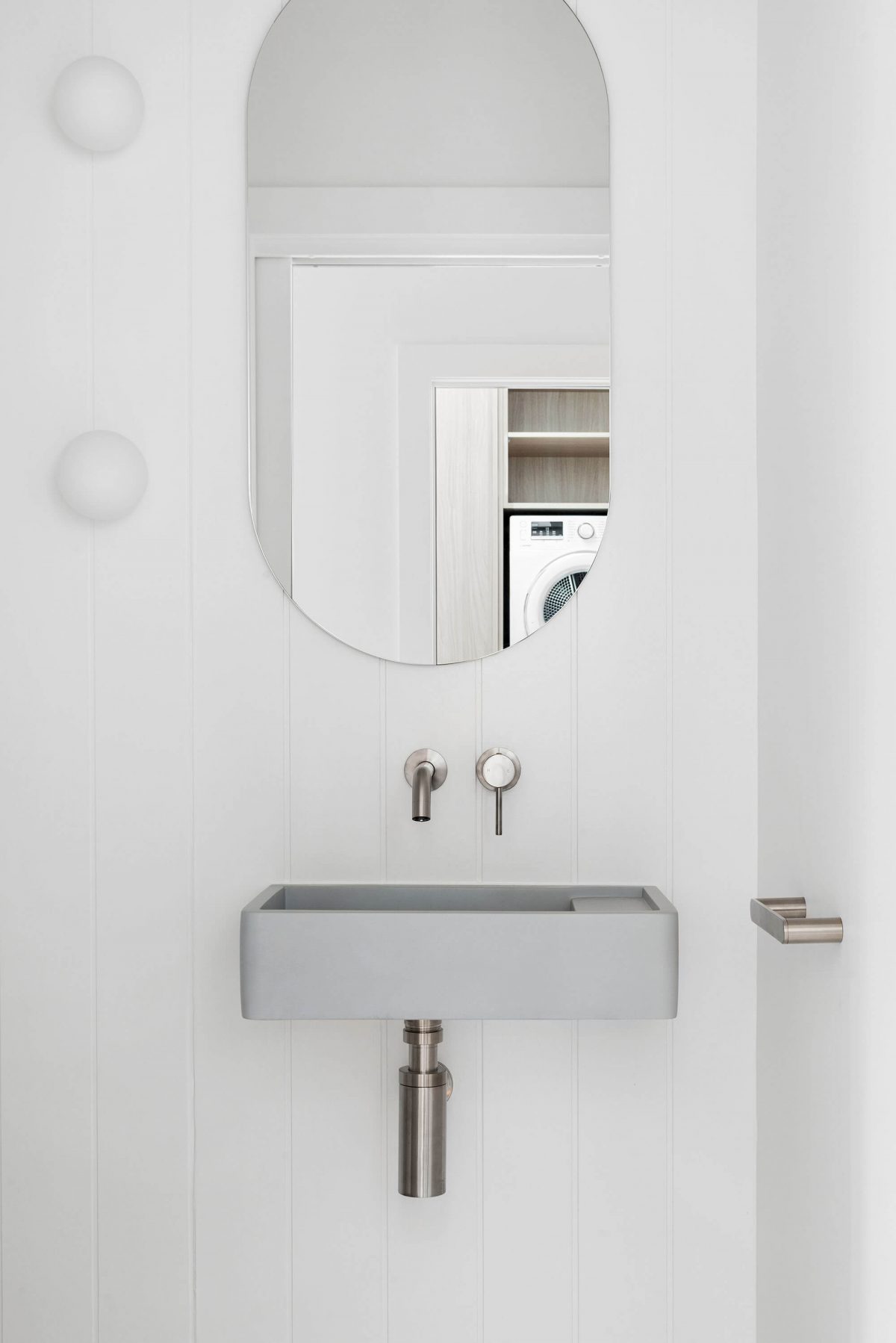 A custom designed bathroom featuring an oval mirror. Designed and built by MJ Harris Group. #MJHxBallantyneSt