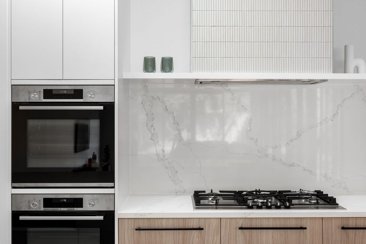 A custom designed kitchen featuring white Kit Kat files and brushed gunmetal tapware. Designed and built by MJ Harris Group. #MJHxBallantyneSt
