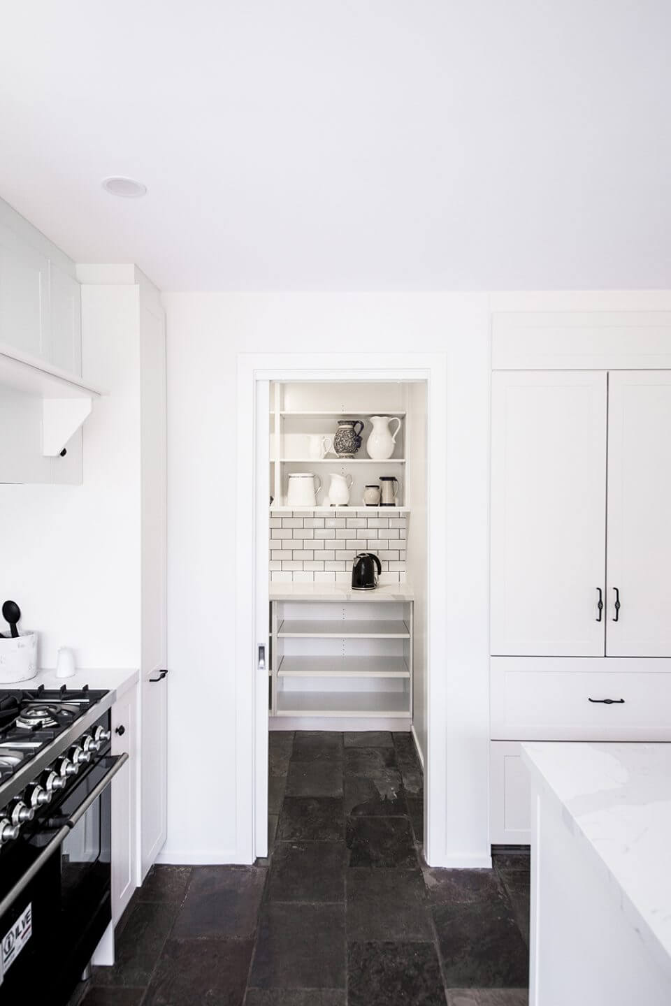 A custom designed pantry off the kitchen. Designed and built by MJ Harris Group.