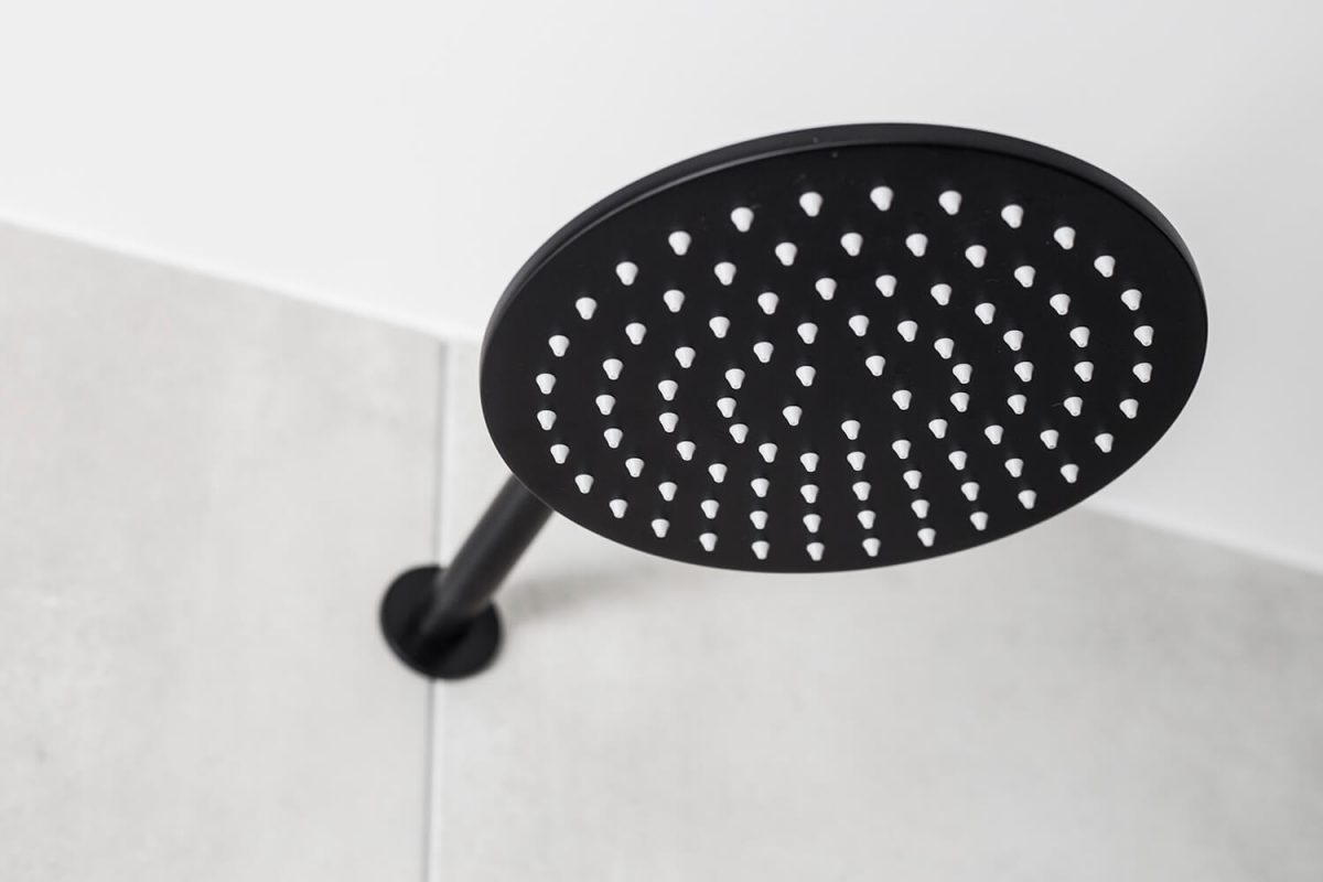 A custom designed bathroom featuring a black shower head. Designed and built by MJ Harris Group. #MJHxWebstersRd