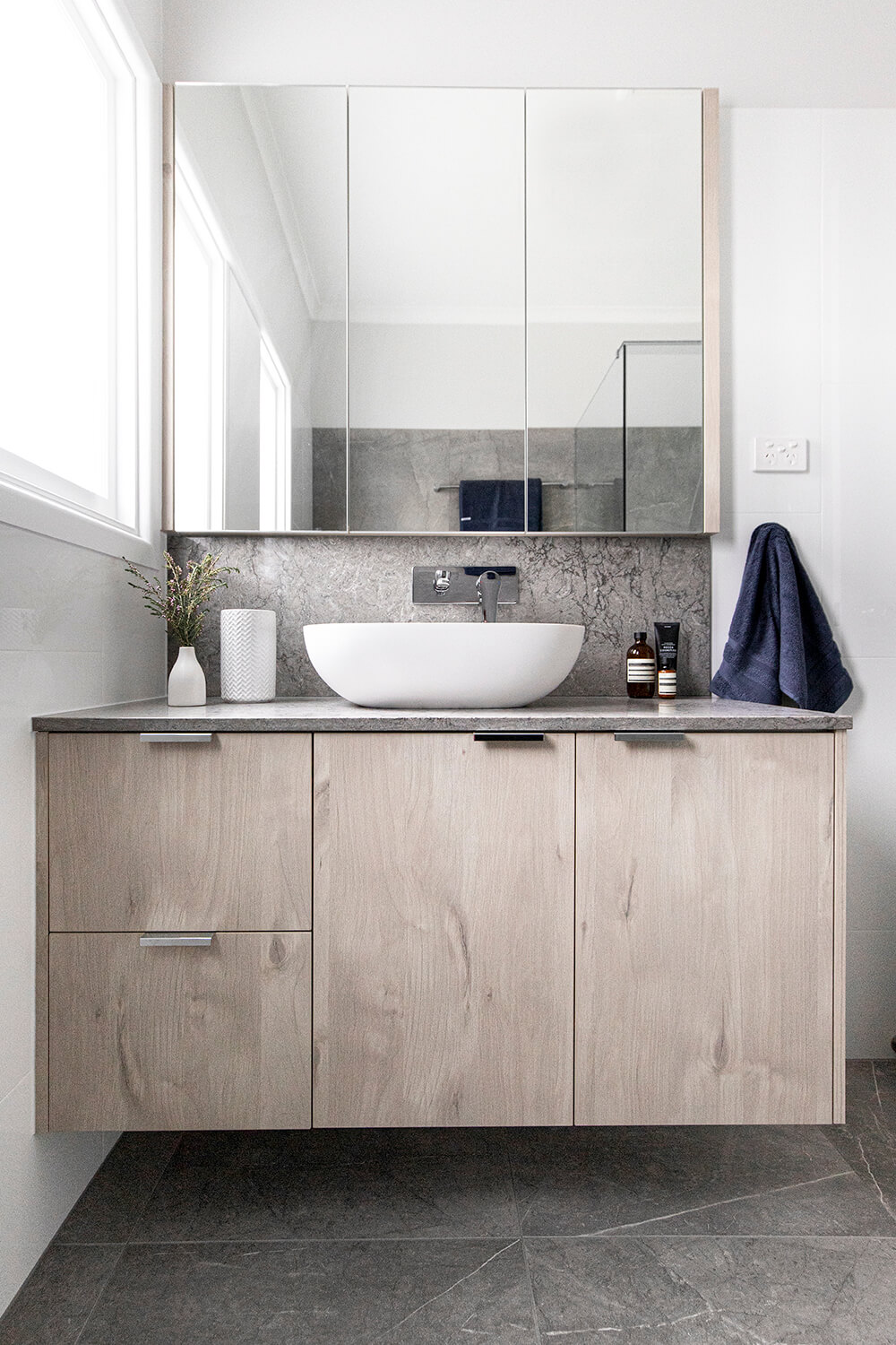 A custom designed bathroom featuring grey tiles. Designed and built by MJ Harris Group.