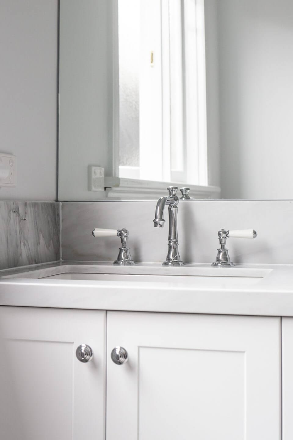 A custom designed bathroom featuring chrome fixtures. Designed and built by MJ Harris Group.