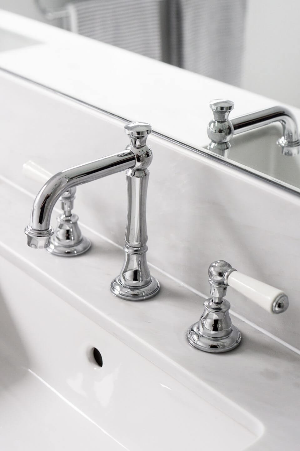 A custom designed bathroom featuring chrome fixtures. Designed and built by MJ Harris Group.